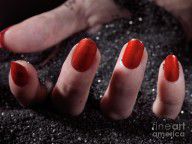 2810157_Woman_Hand_With_Red_Nail_Polish_Buried_In_Black_Sand